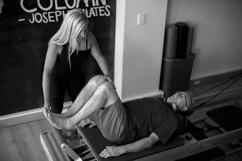 Karol Garcia, certified Pilates instructor and owner of pilateswise, captured in action leading a private Pilates session in a boutique studio and using various Pilates equipment such as mats and reformers to guide her clients through a full-body workout.